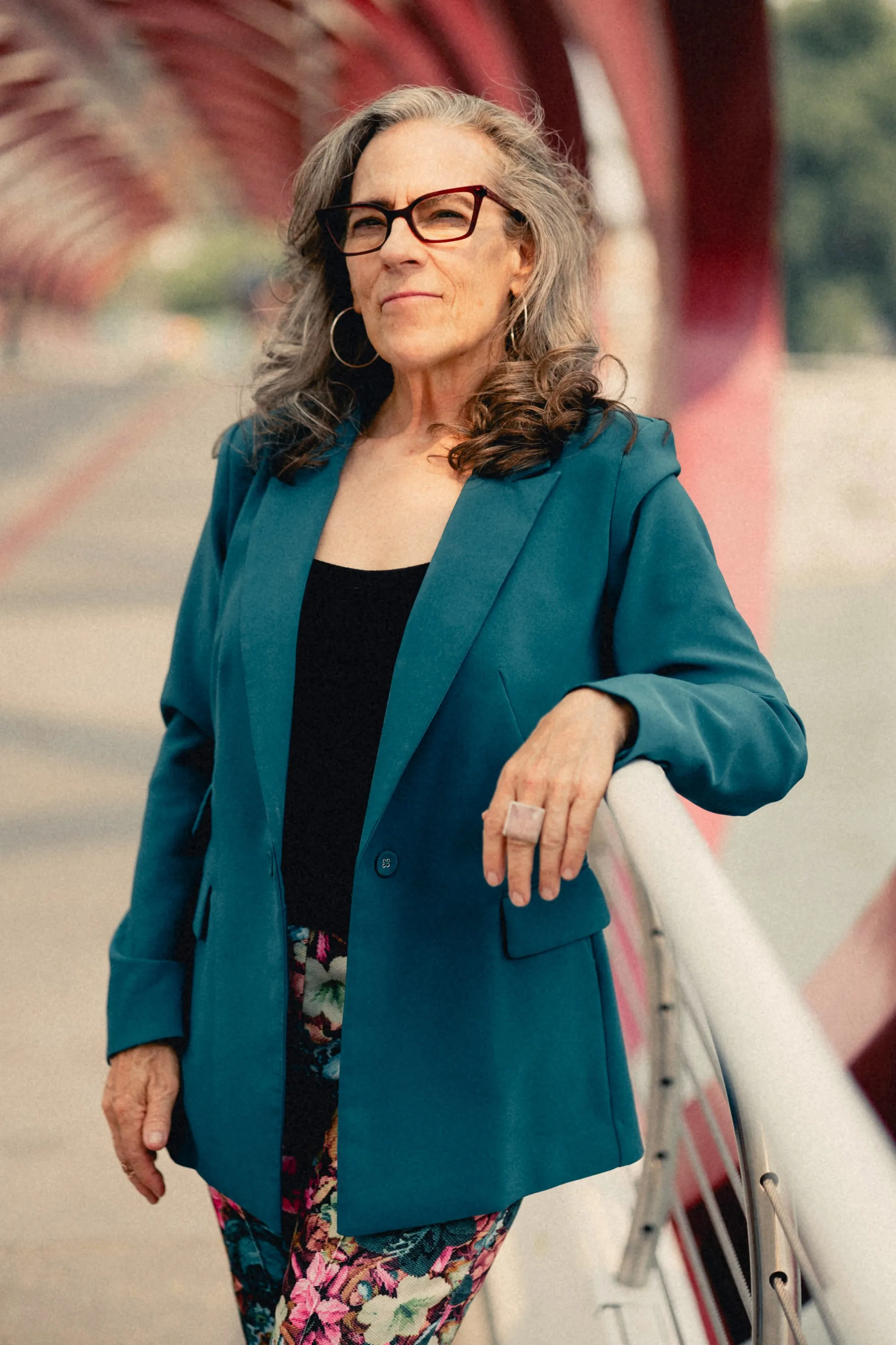 Heidi leaning on the Peace Bridge rail in her teal blazer