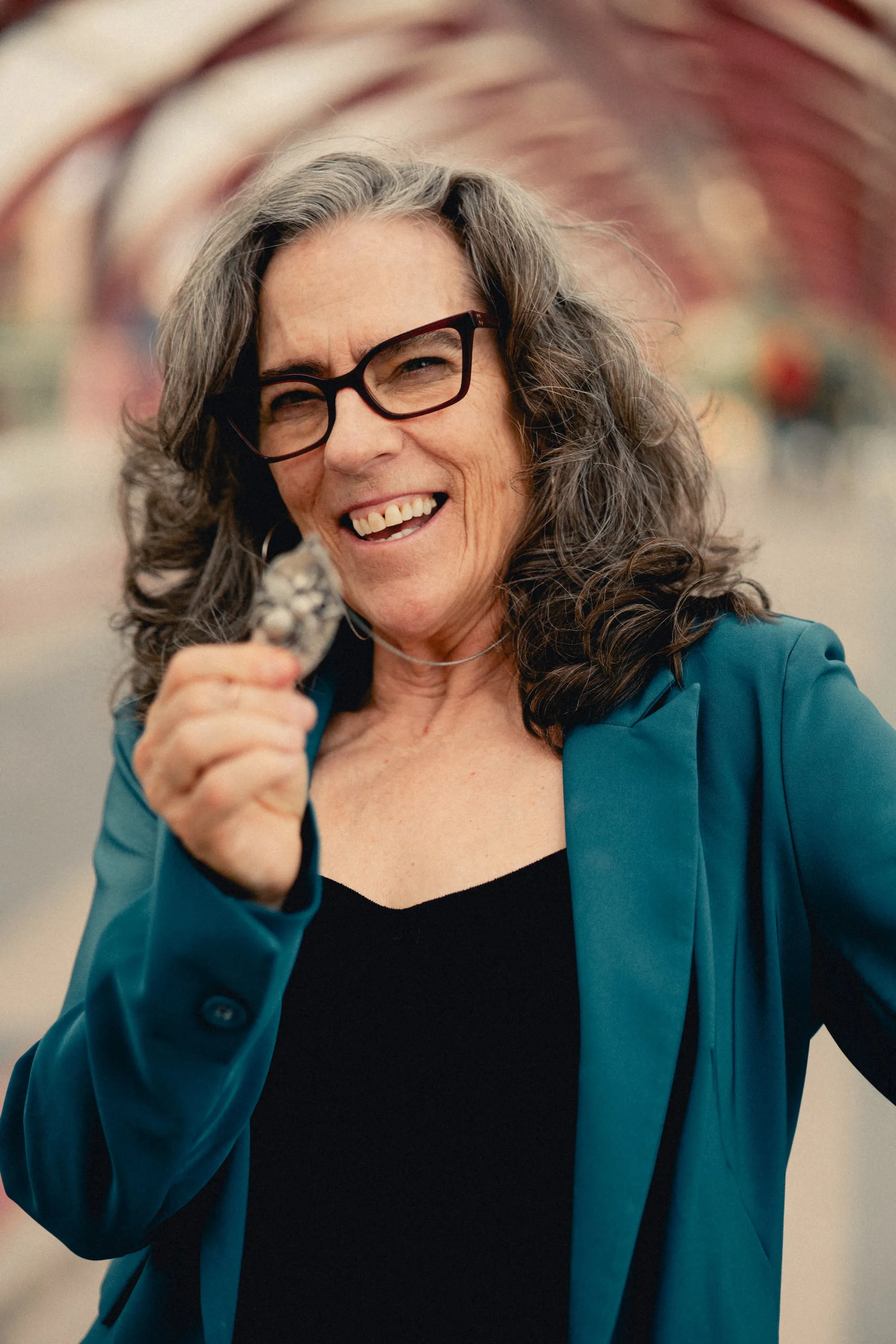 Heidi smiling and holding a small charm on the bridge