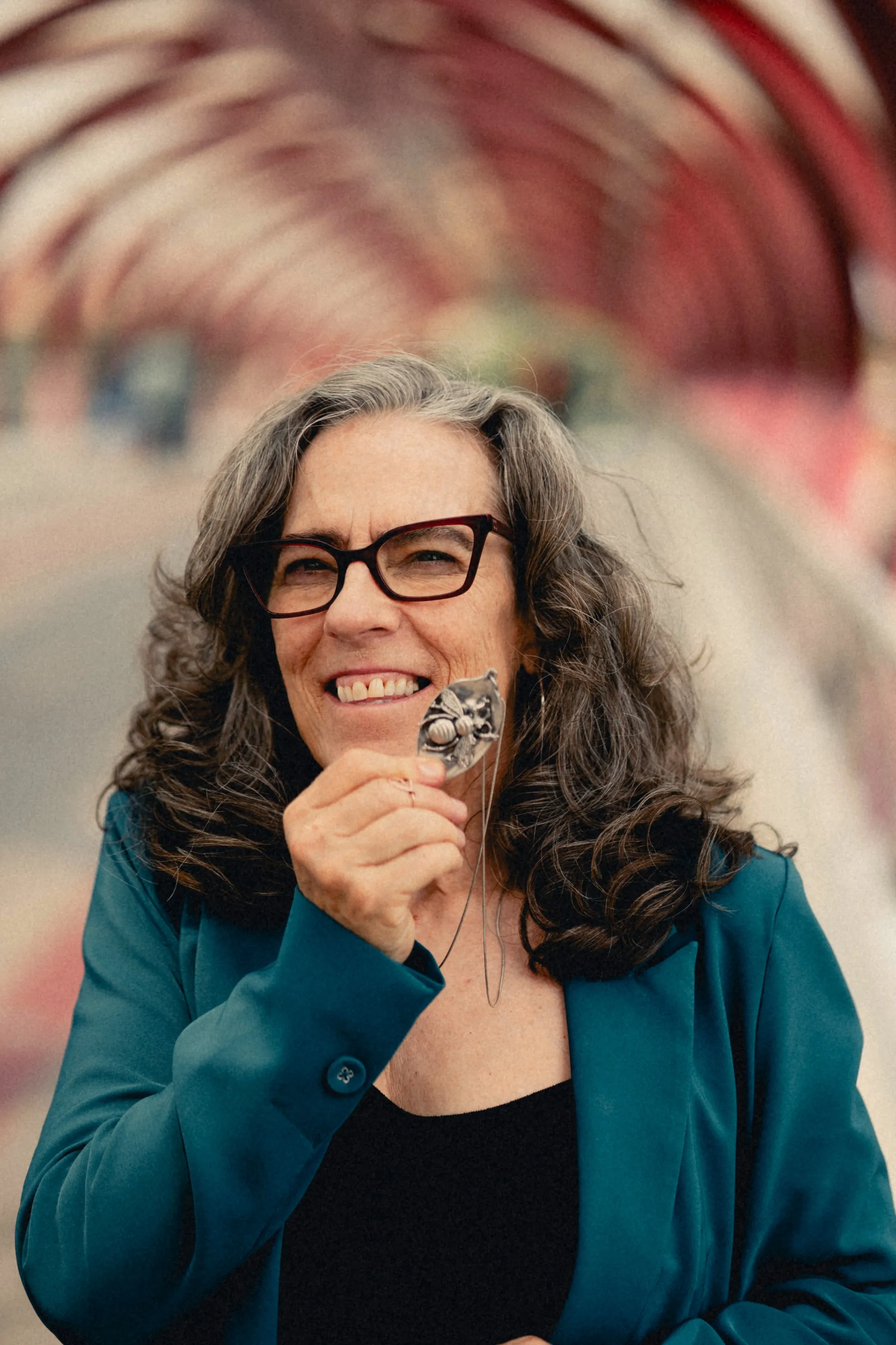 Heidi laughing and holding a charm