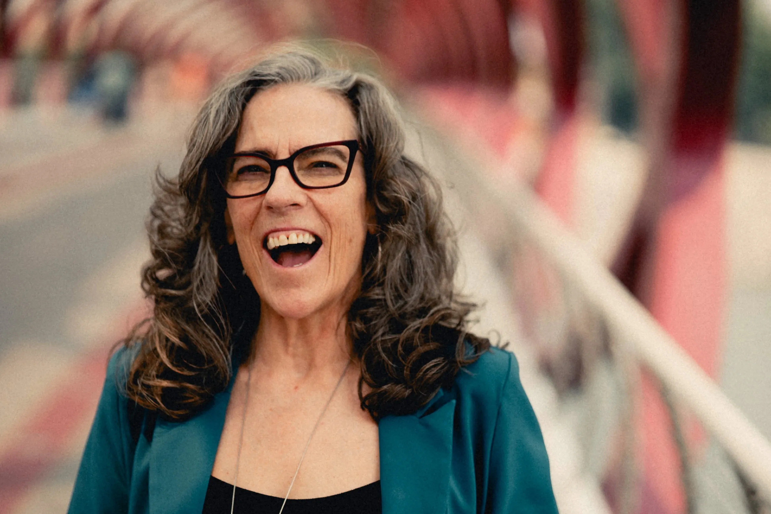 Heidi Barkwell laughing under the red helix of the Peace Bridge
