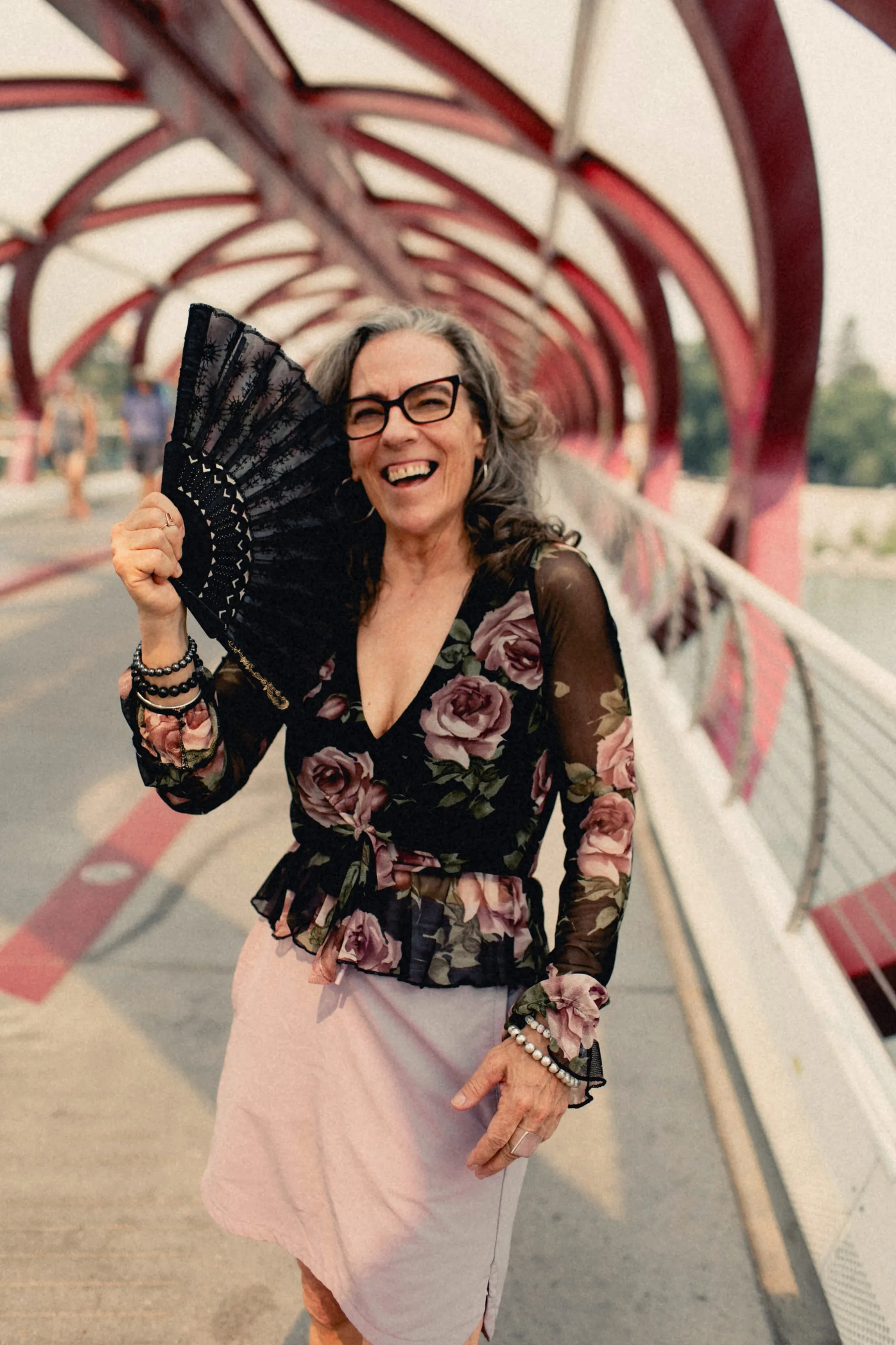 Heidi laughing behind a black lace fan on the Peace Bridge