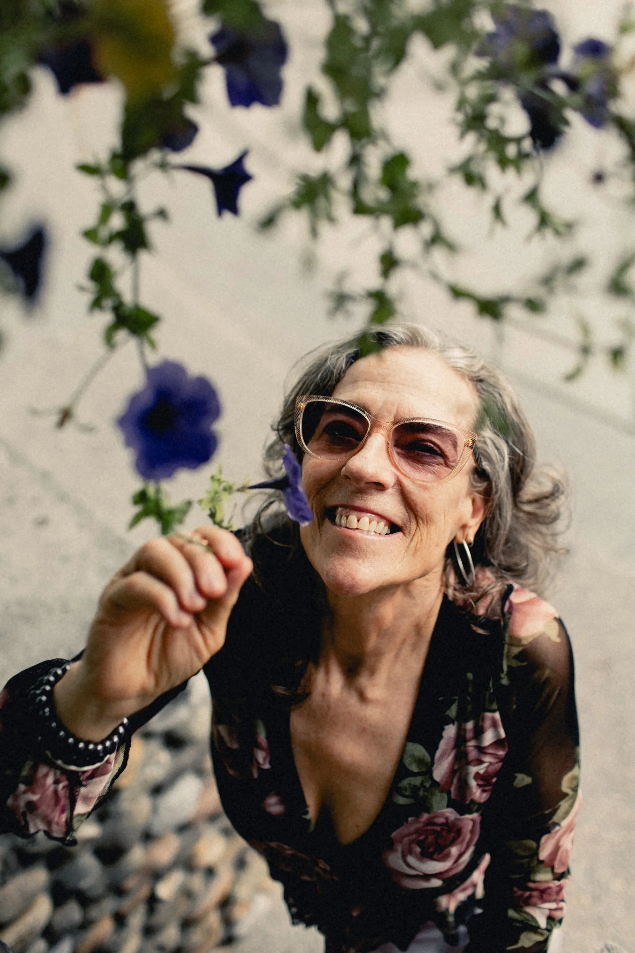 Heidi laughing under a hanging basket of flowers