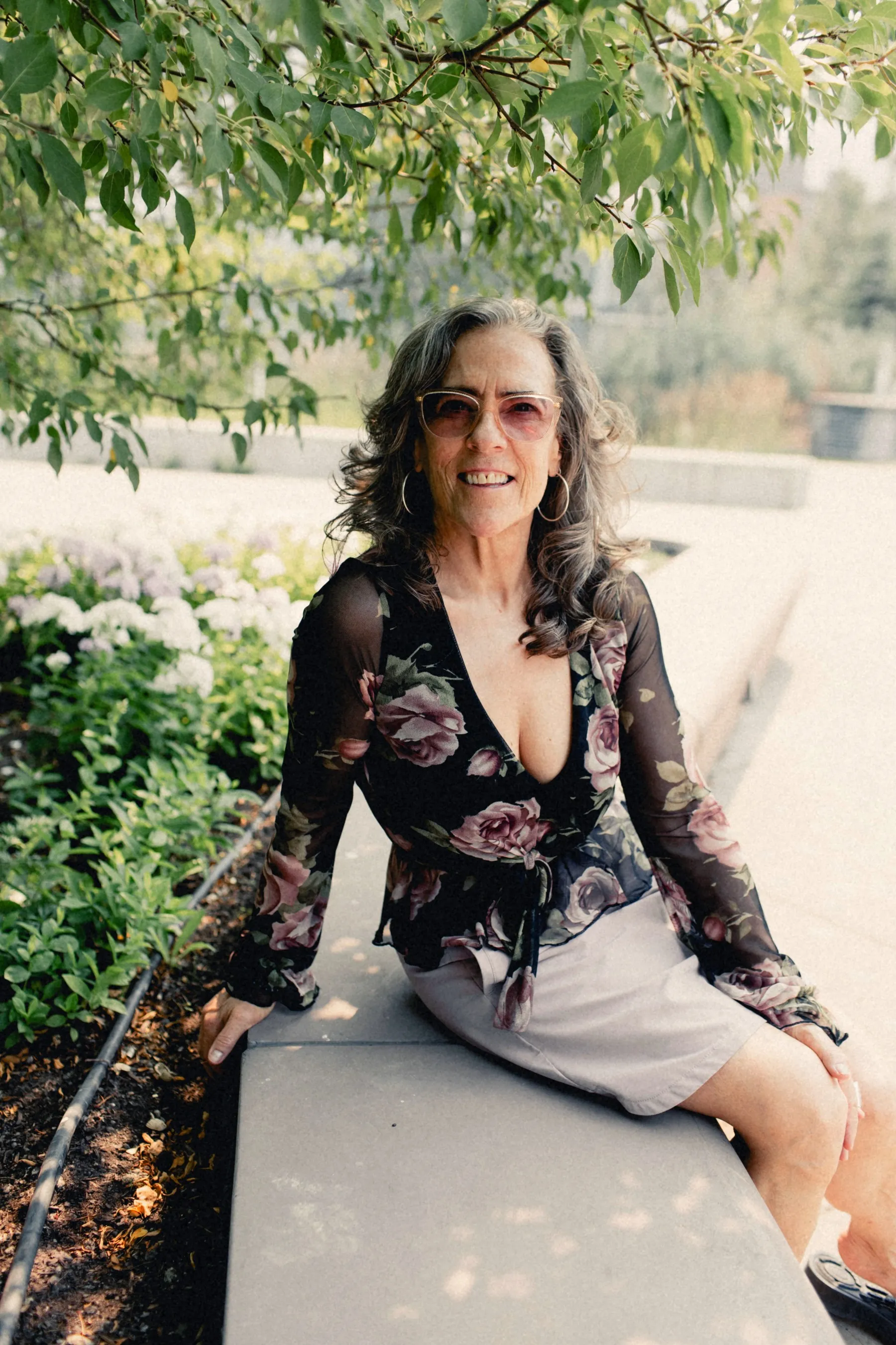 Heidi smiling softly in a white flower garden