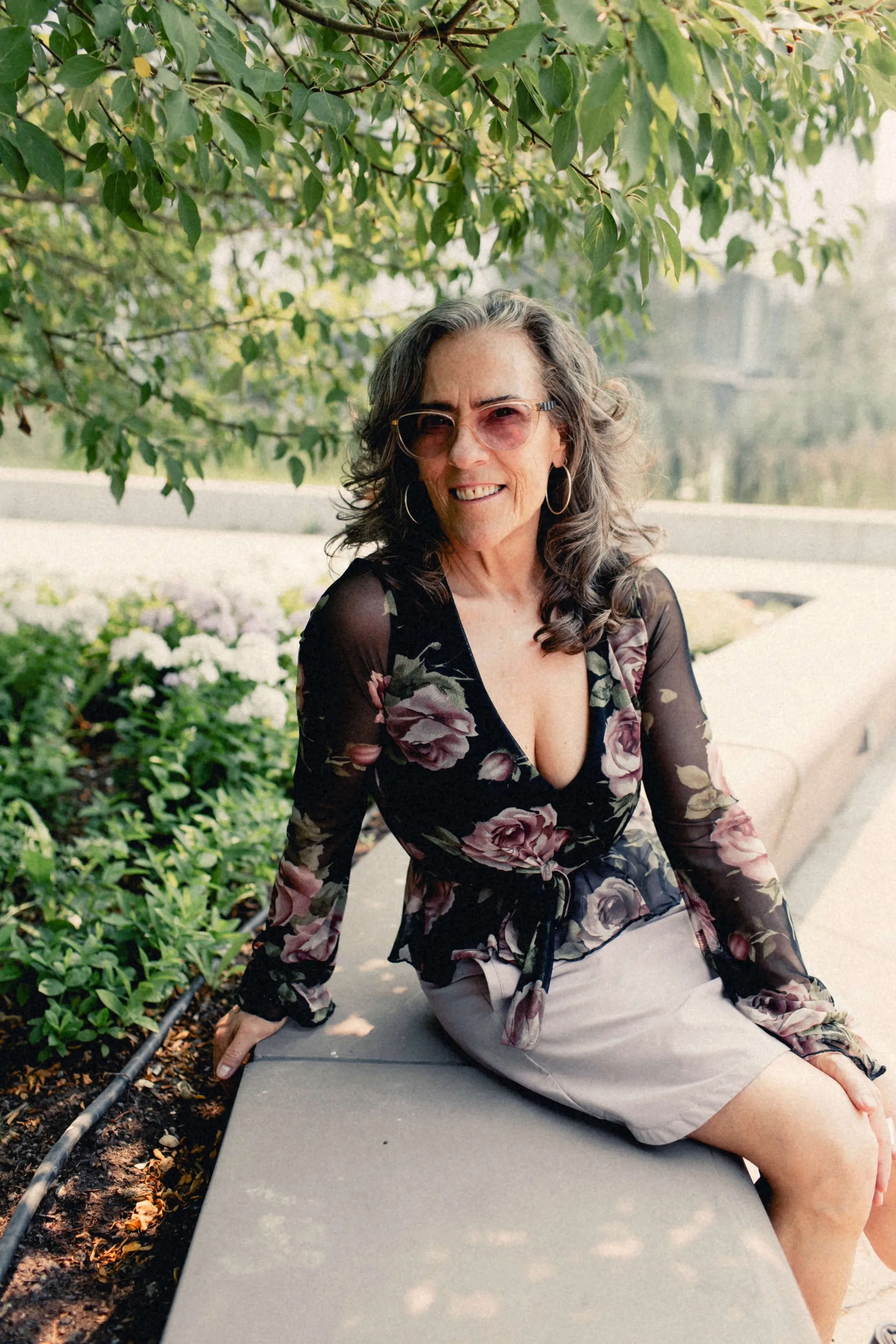 Heidi seated in a garden, smiling softly