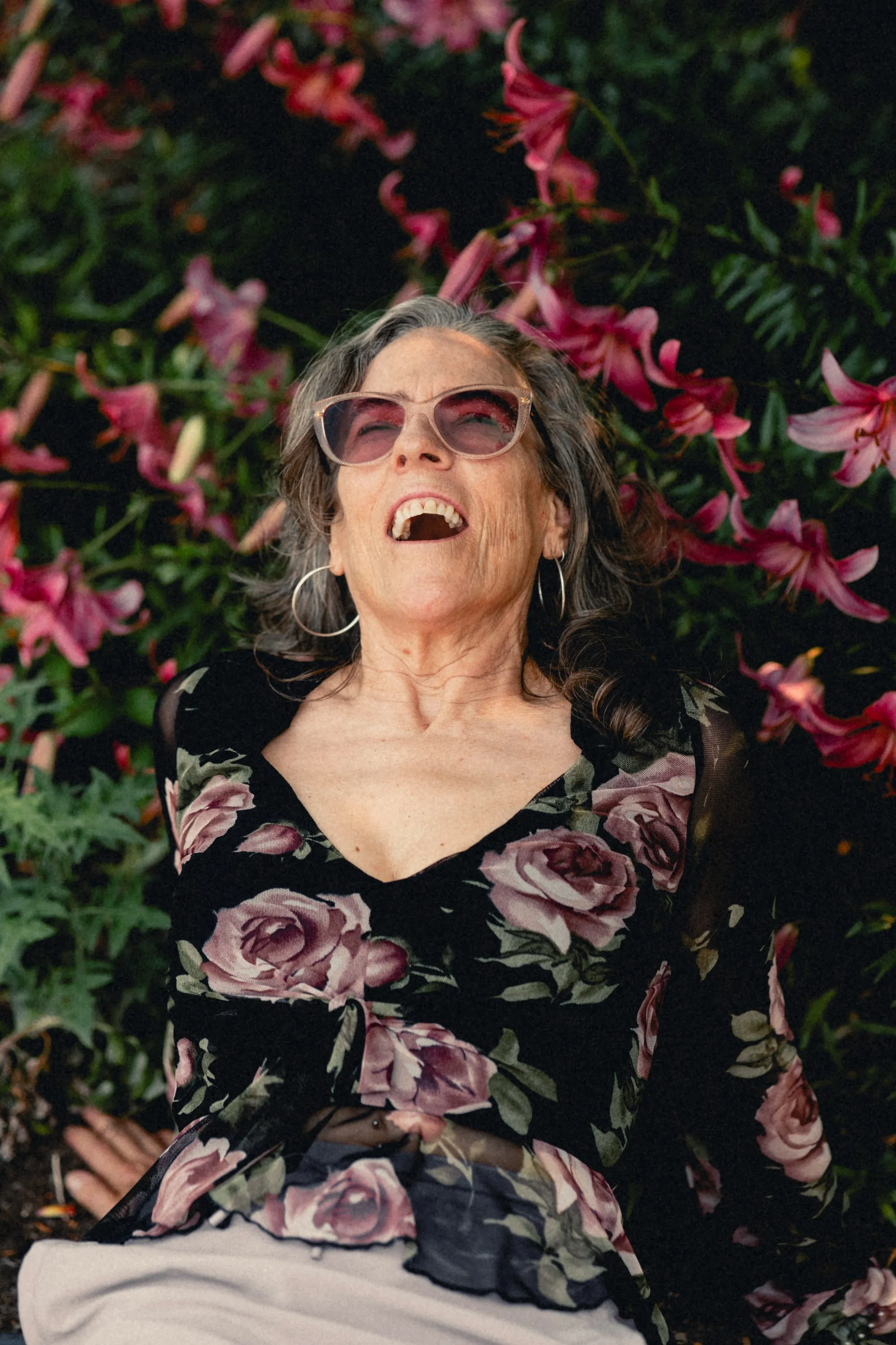Heidi reclining among pink lilies, laughing