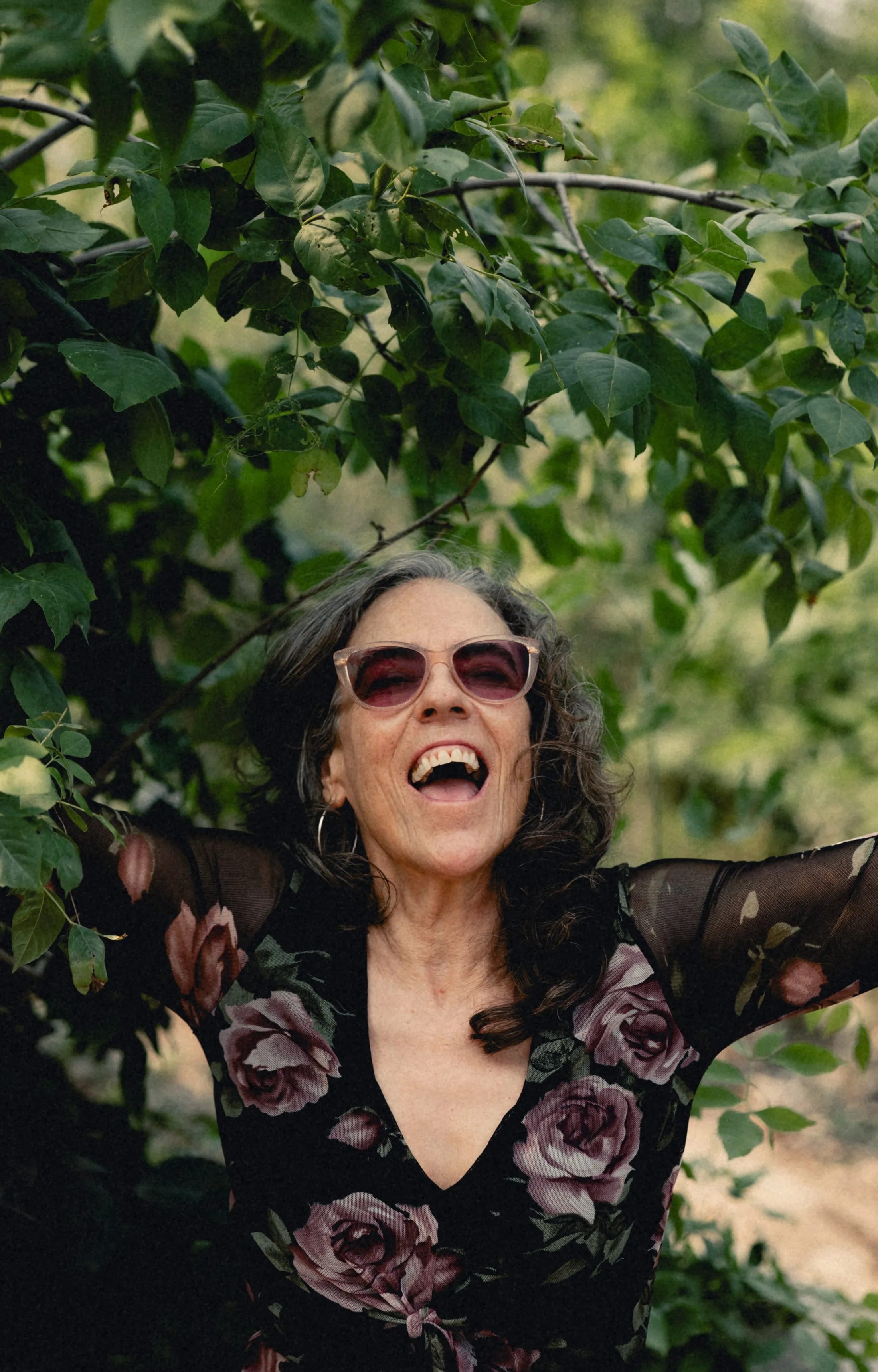 Heidi laughing among green leaves