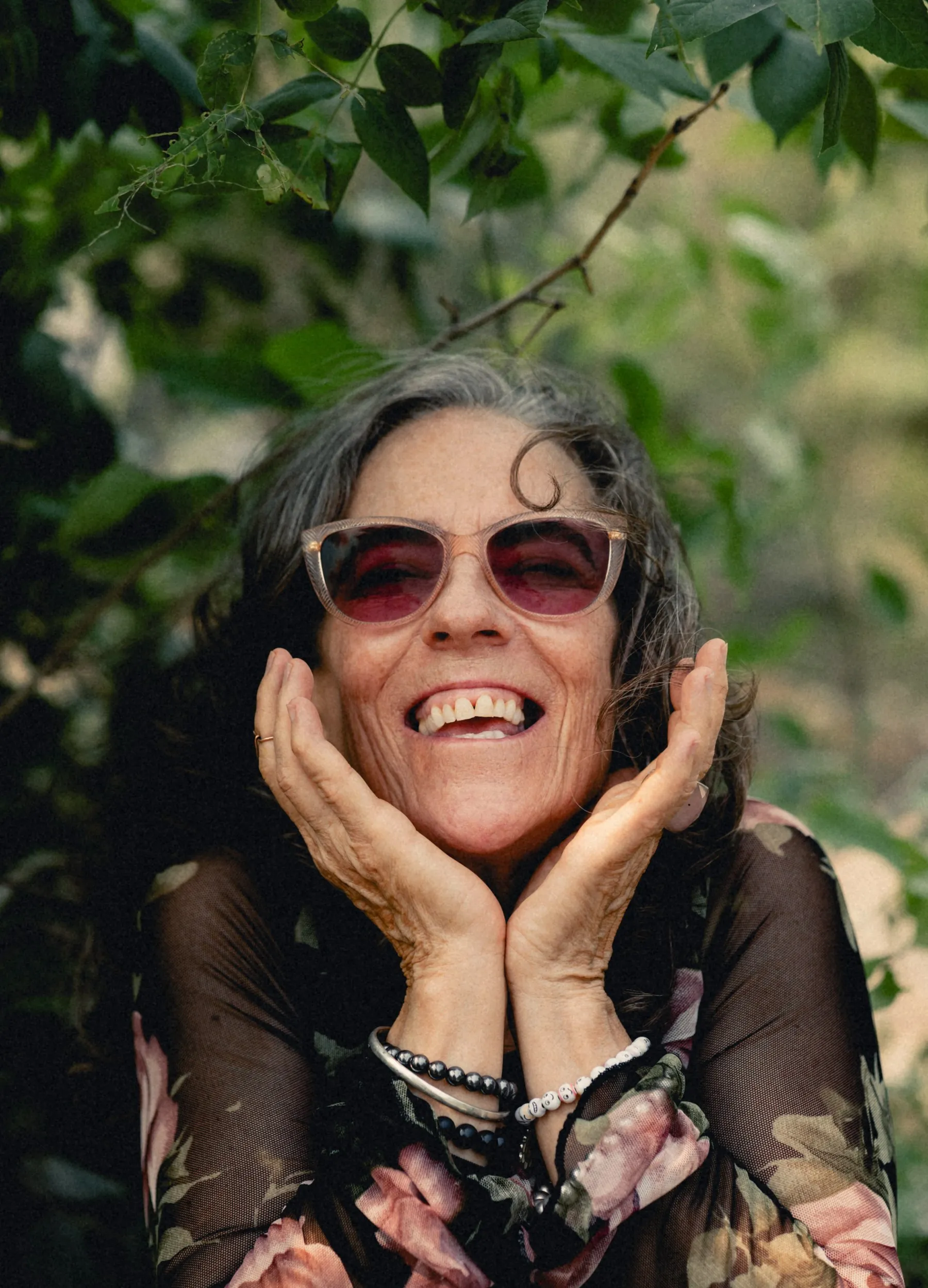Heidi laughing with her chin in her hands by the Bow River