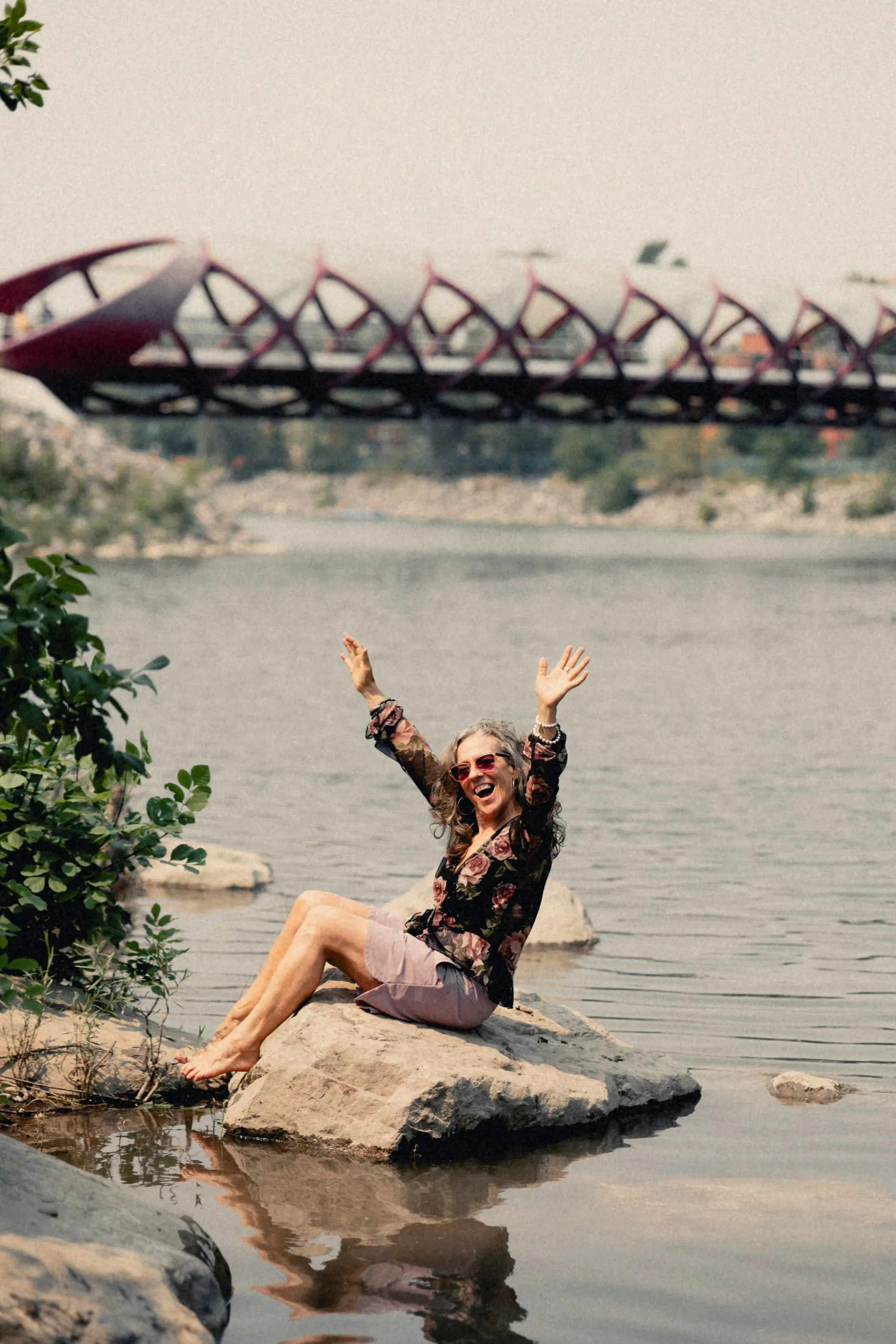 Heidi waving from a rock in the river