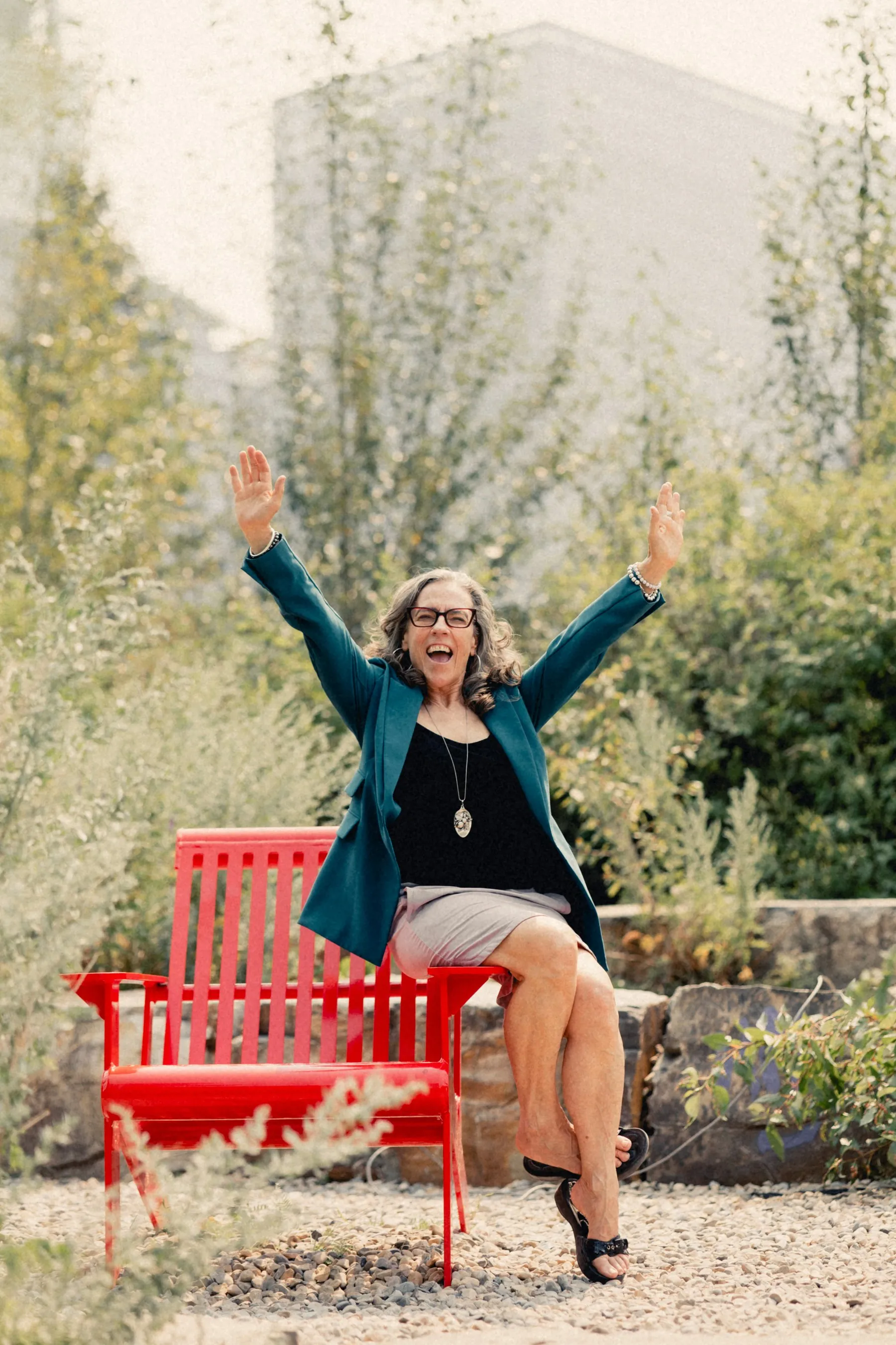 Heidi waving from a red bench